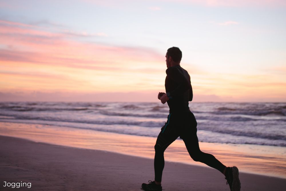 The best holidays to keep active man jogging on beach 17Jan24